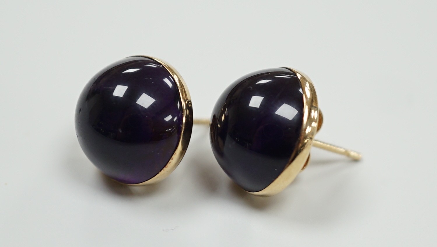 A modern pair of 9ct gold and cabochon amethyst set ear studs, diameter 14mm, gross weight 4 grams.